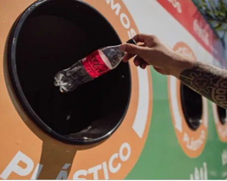 A plastic bottle is placed in a Coca-Cola recycling bin