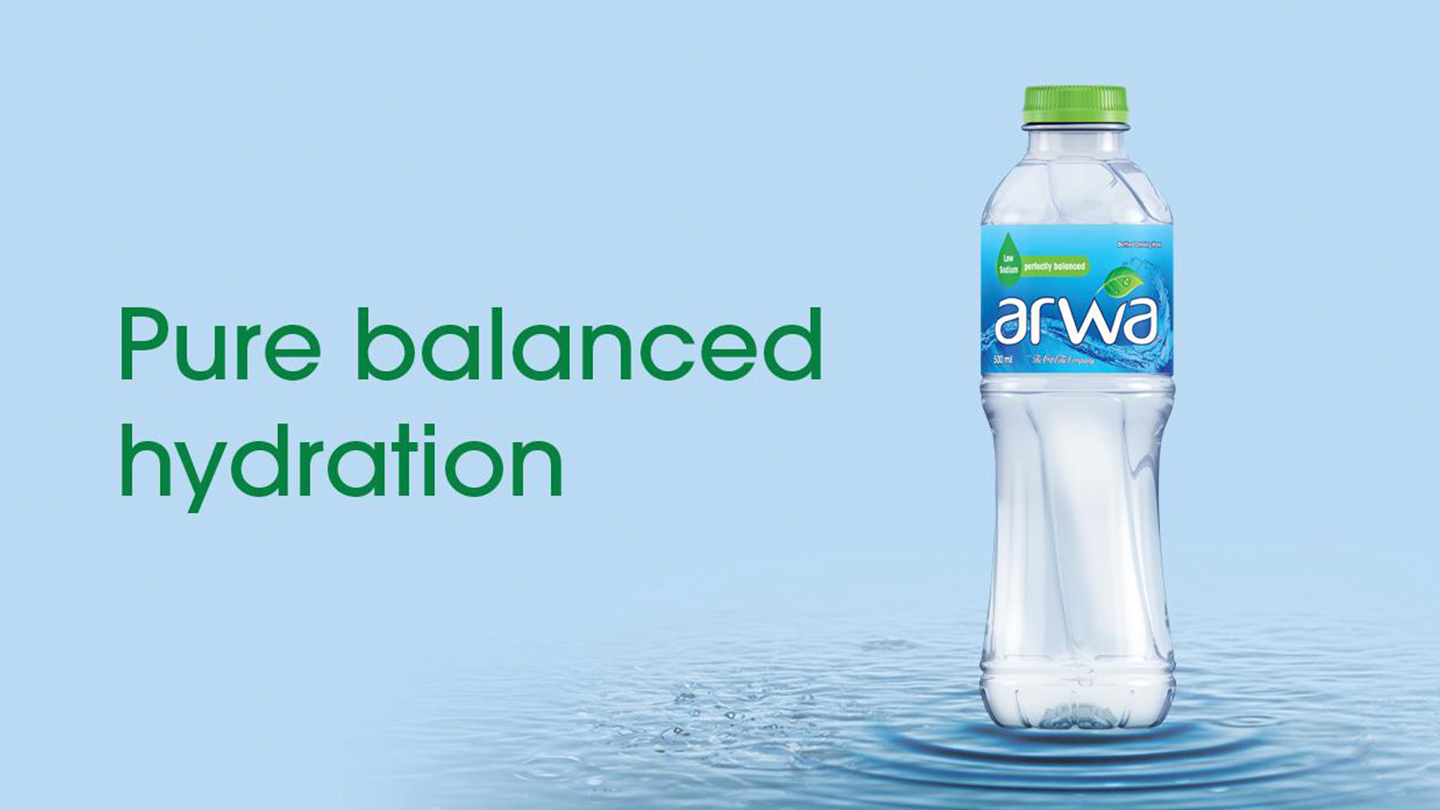 Arwa bottle on light blue background with the phrase 'Pure balanced hydration' displayed beside it