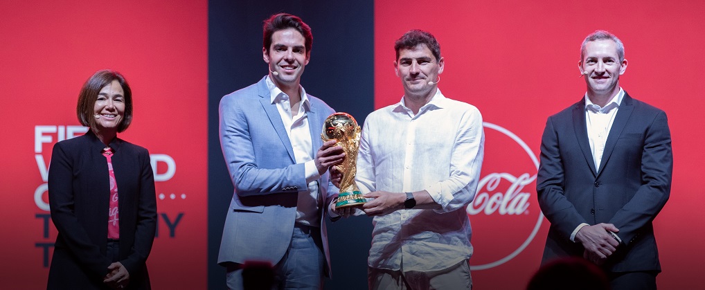 Two man holding the FIFA World Cup™ Original Trophy alongside a woman and a man
