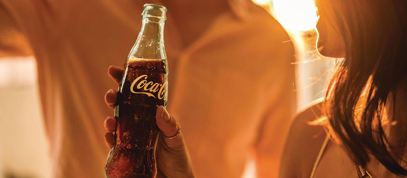 A woman holding a Coca-Cola bottle