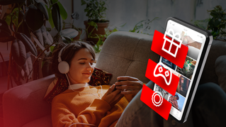 Osoba koristi mobilni telefon sa Coca-Cola aplikacijom i crvenim ikonicama poklona, gejming kontrolera i bedža, uz promotivni tekst